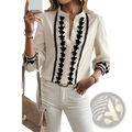 Cream-colored long sleeve blouse with black floral embroidery chain detailing and lace trim on front placket and cuffs