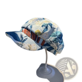 A light blue floral newsboy cap with a striped orange and brown band displayed on a white stand