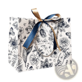 A white paper floral gift bag with black botanical illustration pattern tied with navy blue and gold ribbon bow