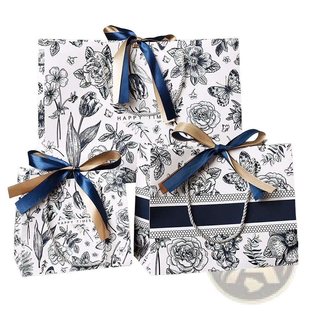 Three elegant floral paper gift bags with black and white patterns accented by navy blue and gold ribbons