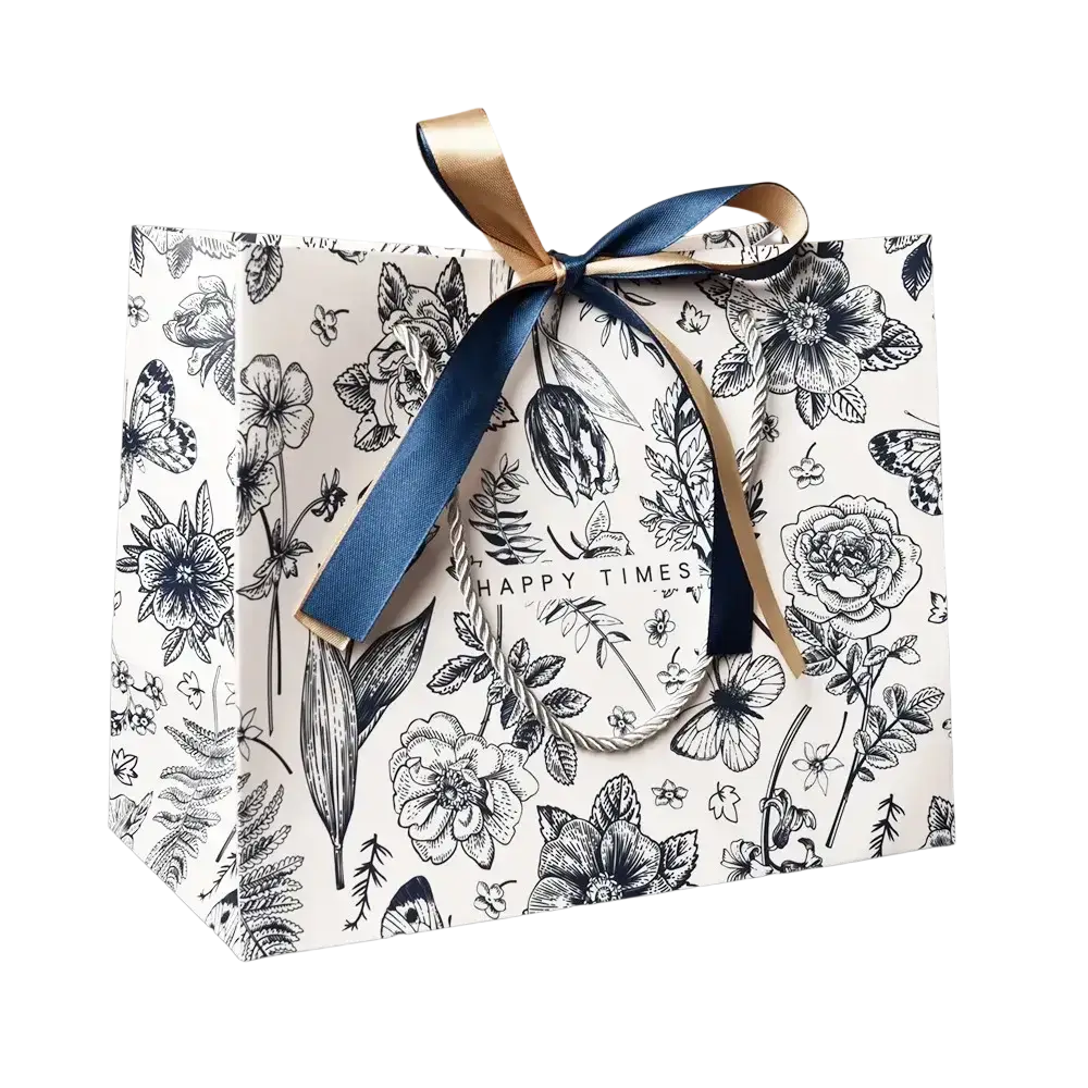 A white paper gift bag with black floral botanical print tied with a navy blue ribbon bow for elegant gift bags