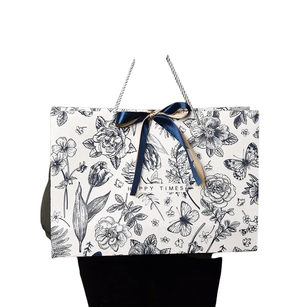 White paper shopping bag with black botanical illustrations and navy blue ribbon bow floral paper gift bag with ribbon