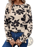 Beige floral print backless blouse with bow featuring black floral design and ruffled long-sleeved cuffs