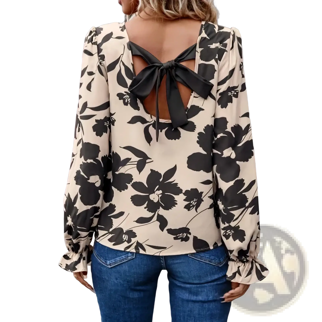 Beige floral print backless blouse with black oversized flowers and a tied bow detail at the back