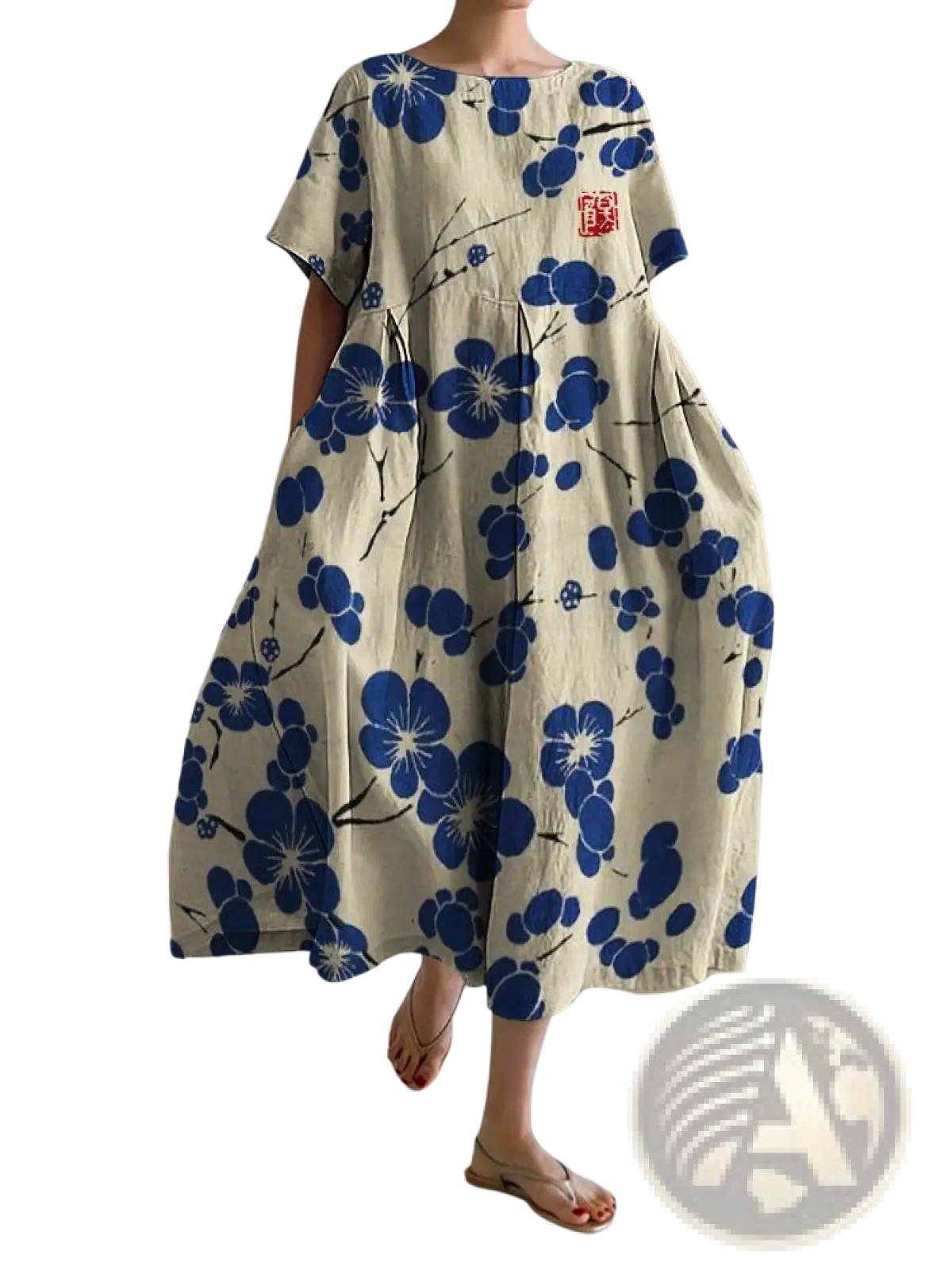 Beige linen plus size A-line maxi dress with bold blue floral pattern and small red embroidered chest patch
