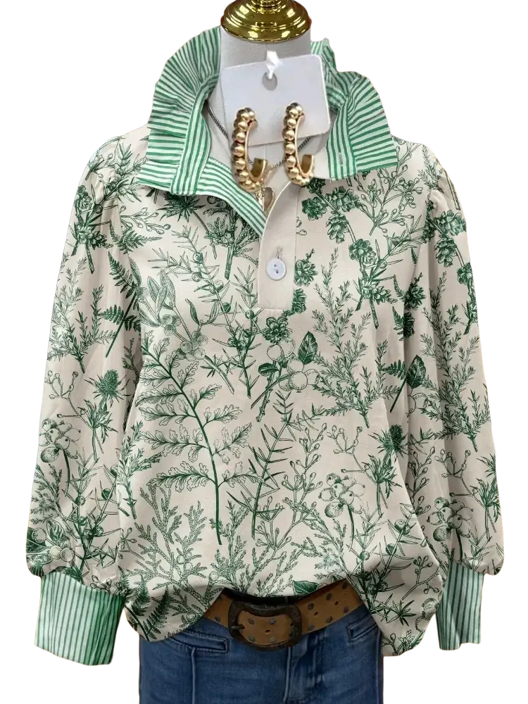 A cream-colored long sleeve casual shirt with green floral print and striped collar and cuffs on a mannequin
