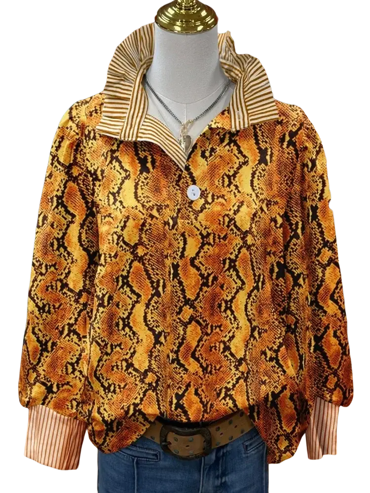 A vibrant orange and black snake print long sleeve casual shirt with striped collar and cuffs on a mannequin