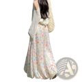 A flowing off-white floral print midi skirt with delicate pink and blue floral patterns in soft fabric