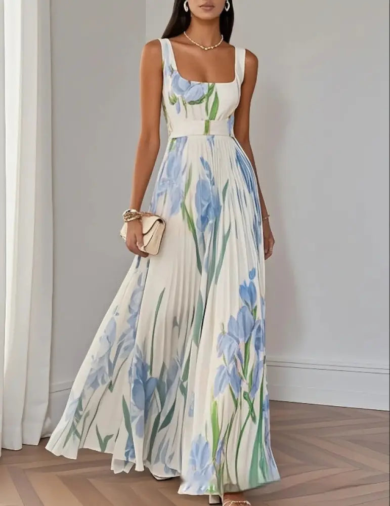A flowing white maxi dress with blue iris floral pattern featuring a square neckline thin straps and pleated skirt