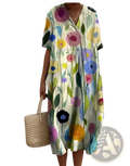 A woman wears a floral print v neck loose maxi dress in vibrant pink blue yellow and purple on light green background