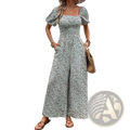 A woman wearing a light green and white floral puff sleeve wide leg jumpsuit with square neckline