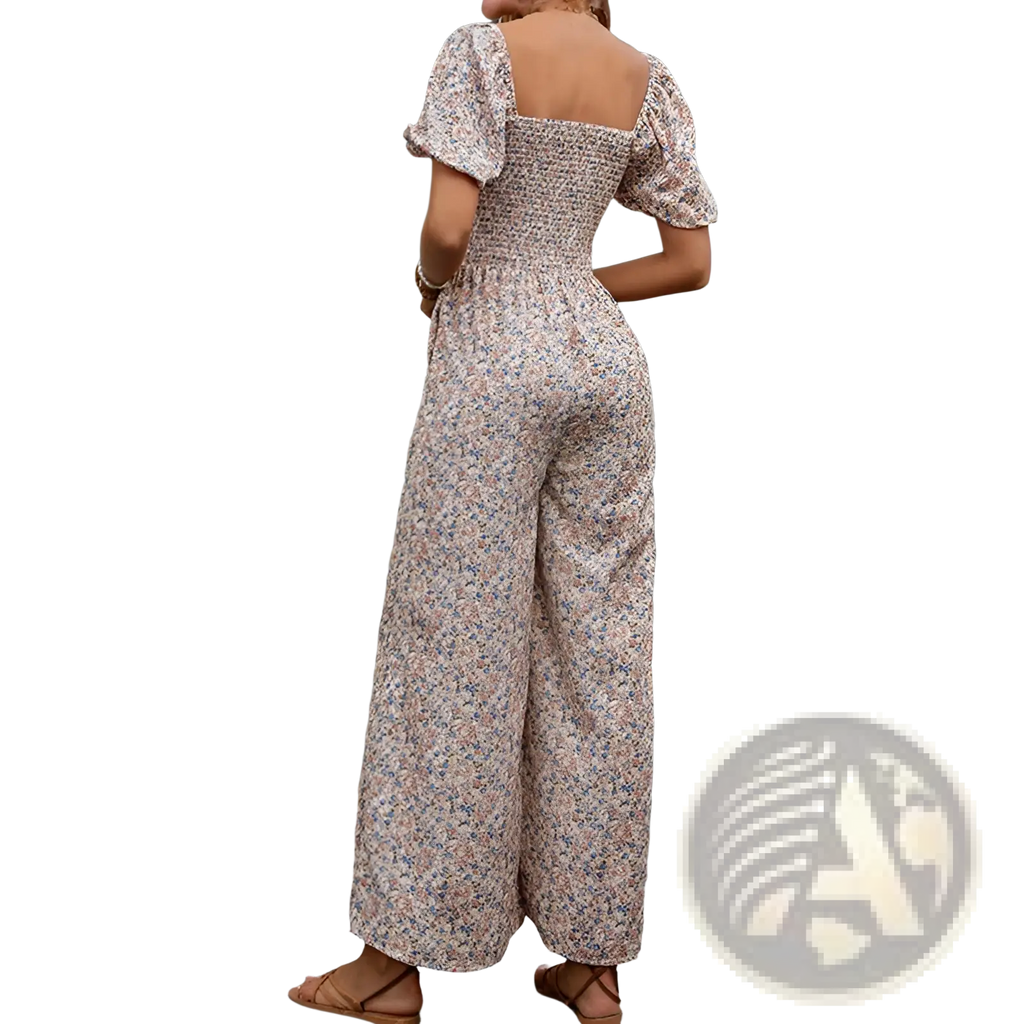 A woman wearing a beige floral print jumpsuit with puffed short sleeves and wide leg pants in a floral puff sleeve wide leg jumpsuit