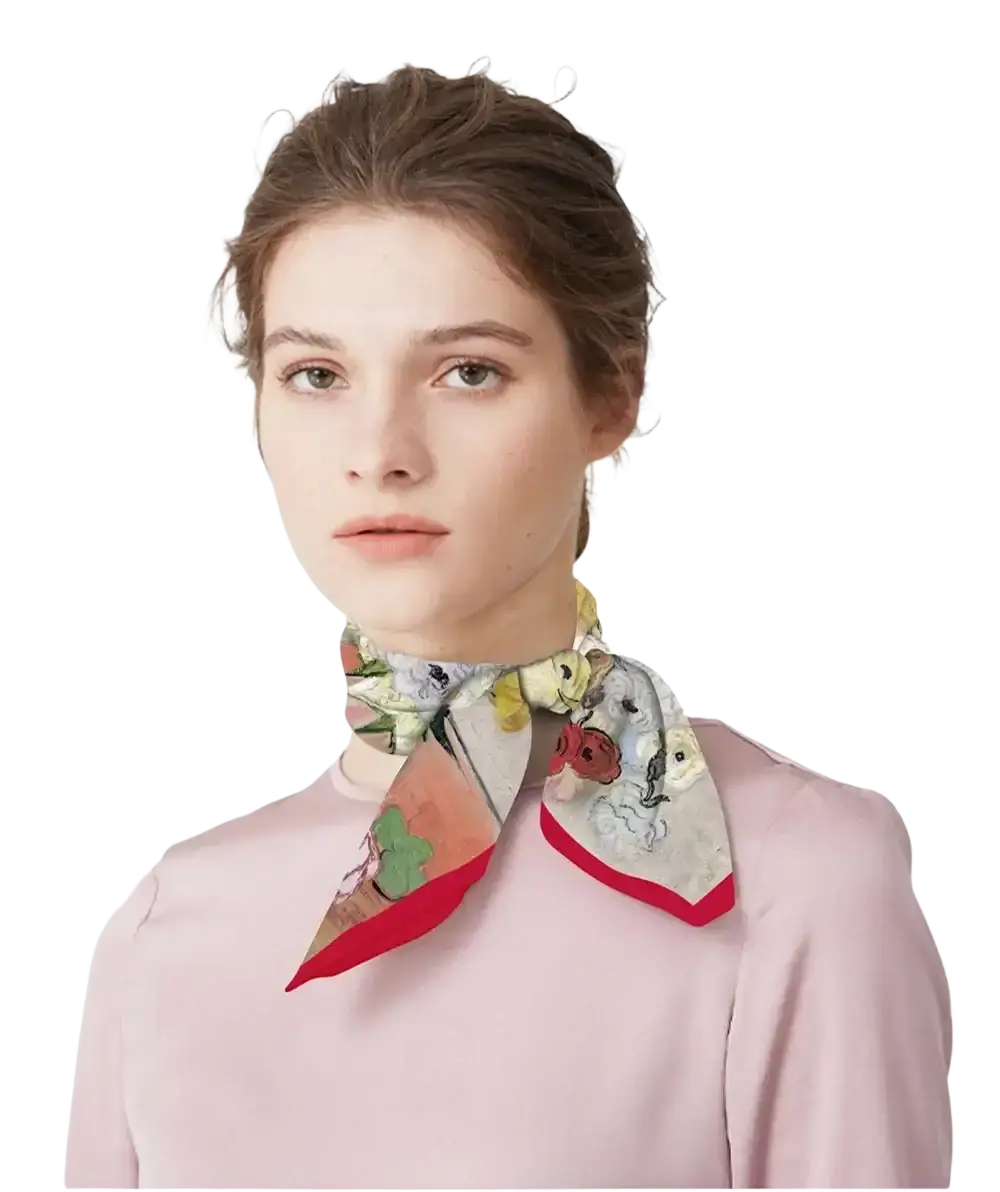 A delicate floral-patterned silk square scarf with a vibrant red border elegantly tied around the neck
