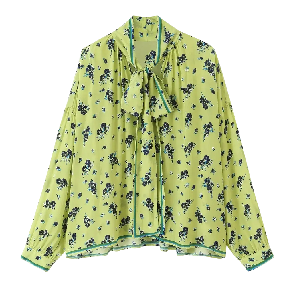 A light green floral two piece midi skirt set with black pattern teal trim long sleeves and tied neck detail