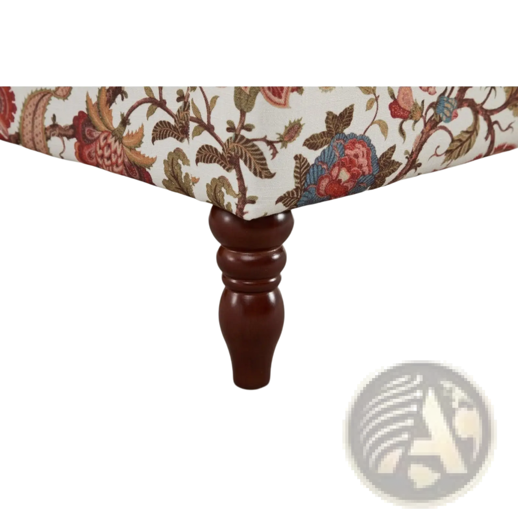 Dark brown wooden leg with ornate turned design supporting floral wingback accent chair upholstery
