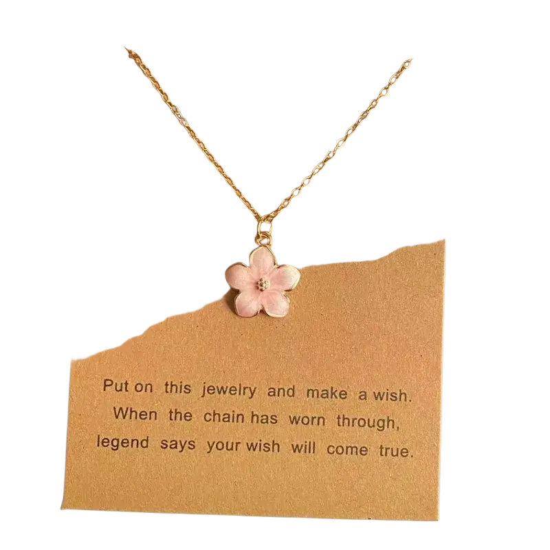 A delicate gold link chain flower pendant necklace with a cute romantic pink enamel cherry blossom and clear gemstone