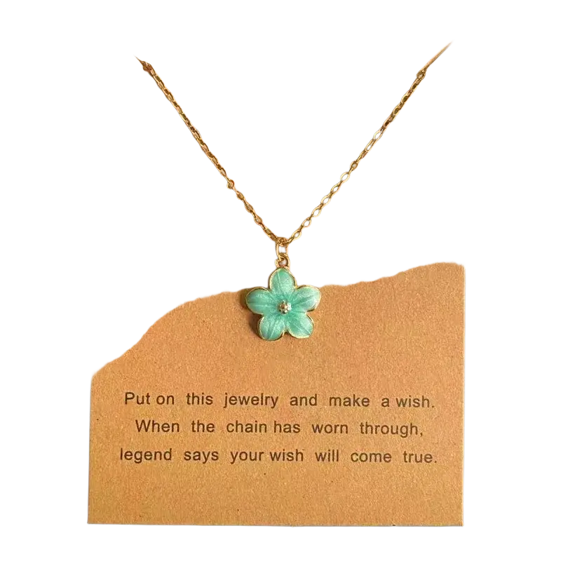 A delicate gold link chain flower pendant necklace with a turquoise enamel flower and clear gemstone center