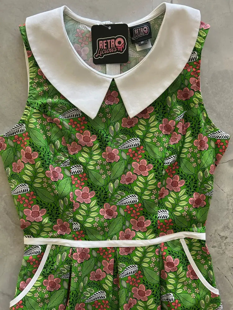 A vibrant green cotton a-line dress with pink floral pattern and white peter pan collar and waistband trim