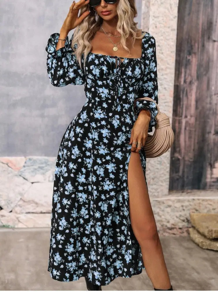 A black floral print midi dress with light blue flowers long sleeves and a square neckline with a slit detail