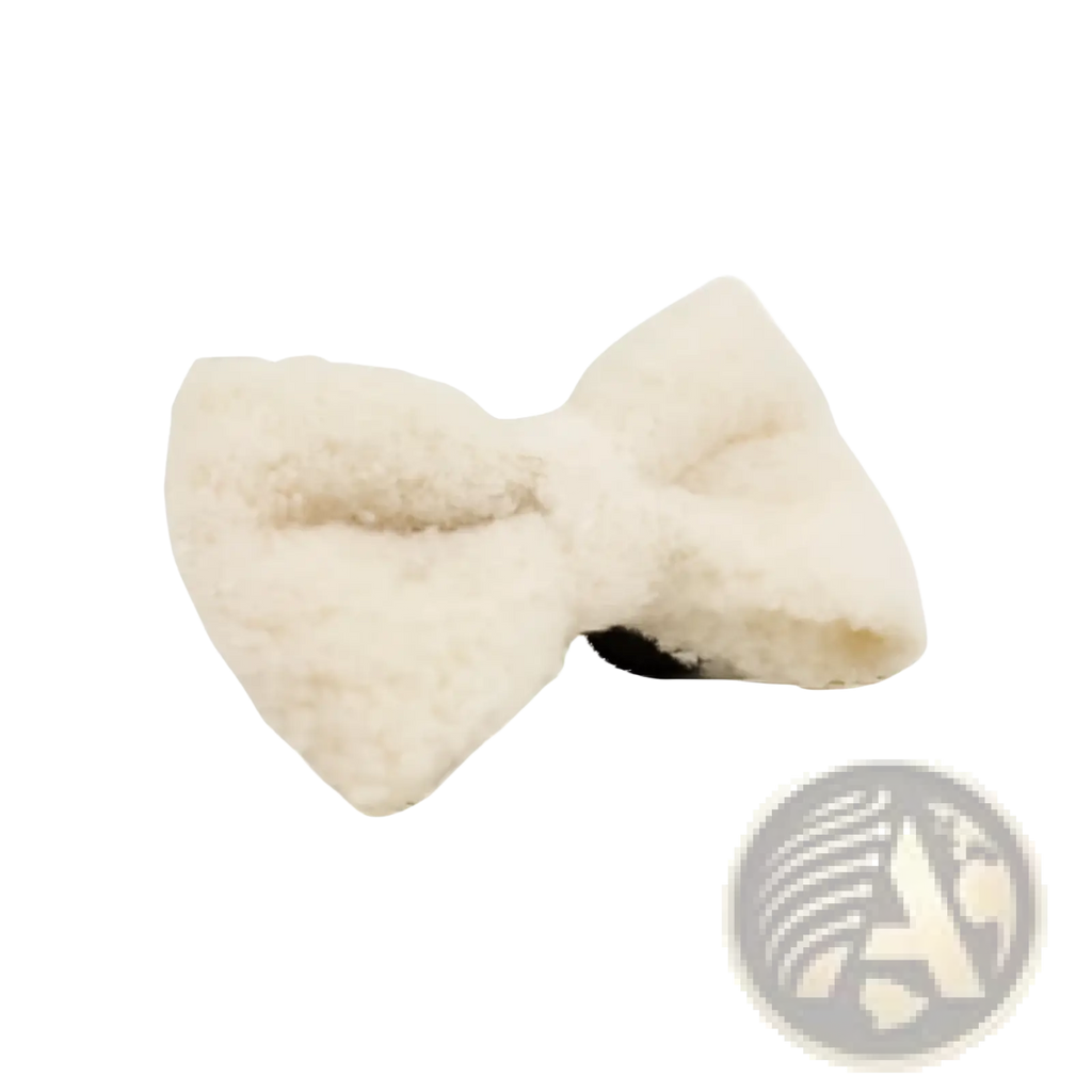A fluffy cream-colored bow hair clip made of soft sheepskin with a textured surface for stylish hair styling