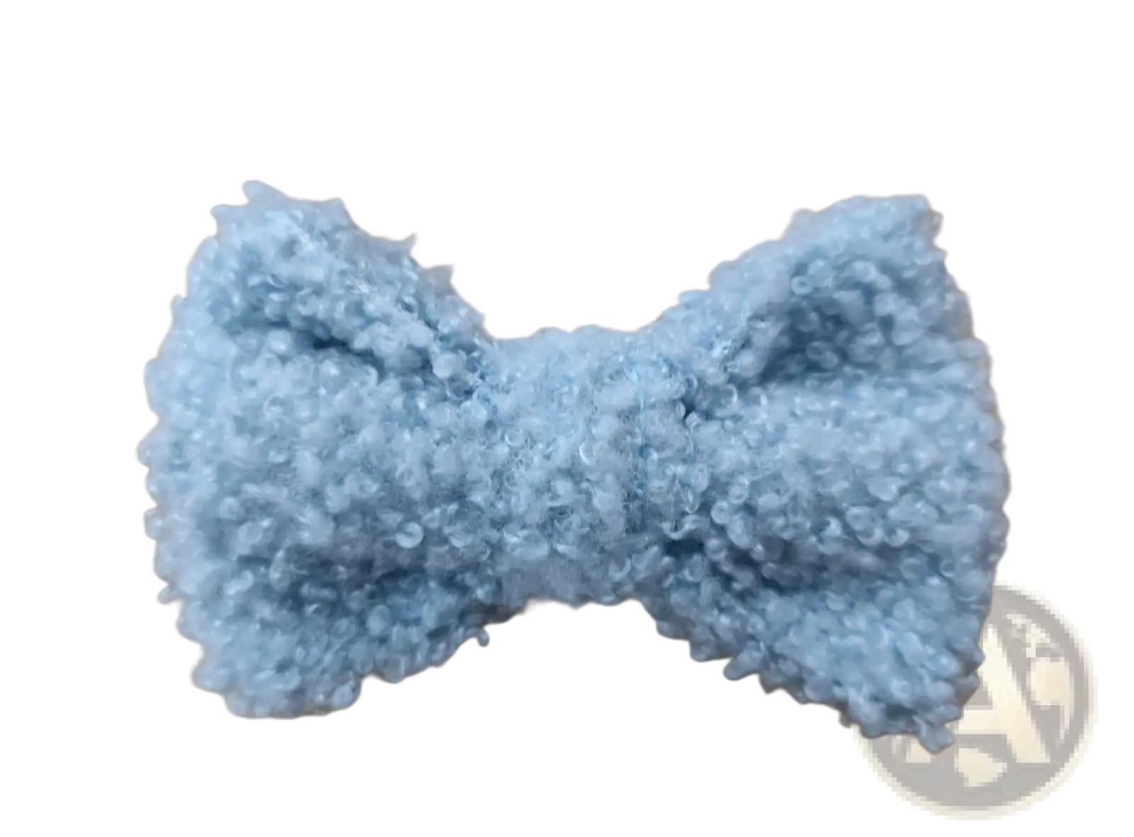 A soft light blue crocheted fluffy bow hair clip made of cream sheepskin with a textured surface