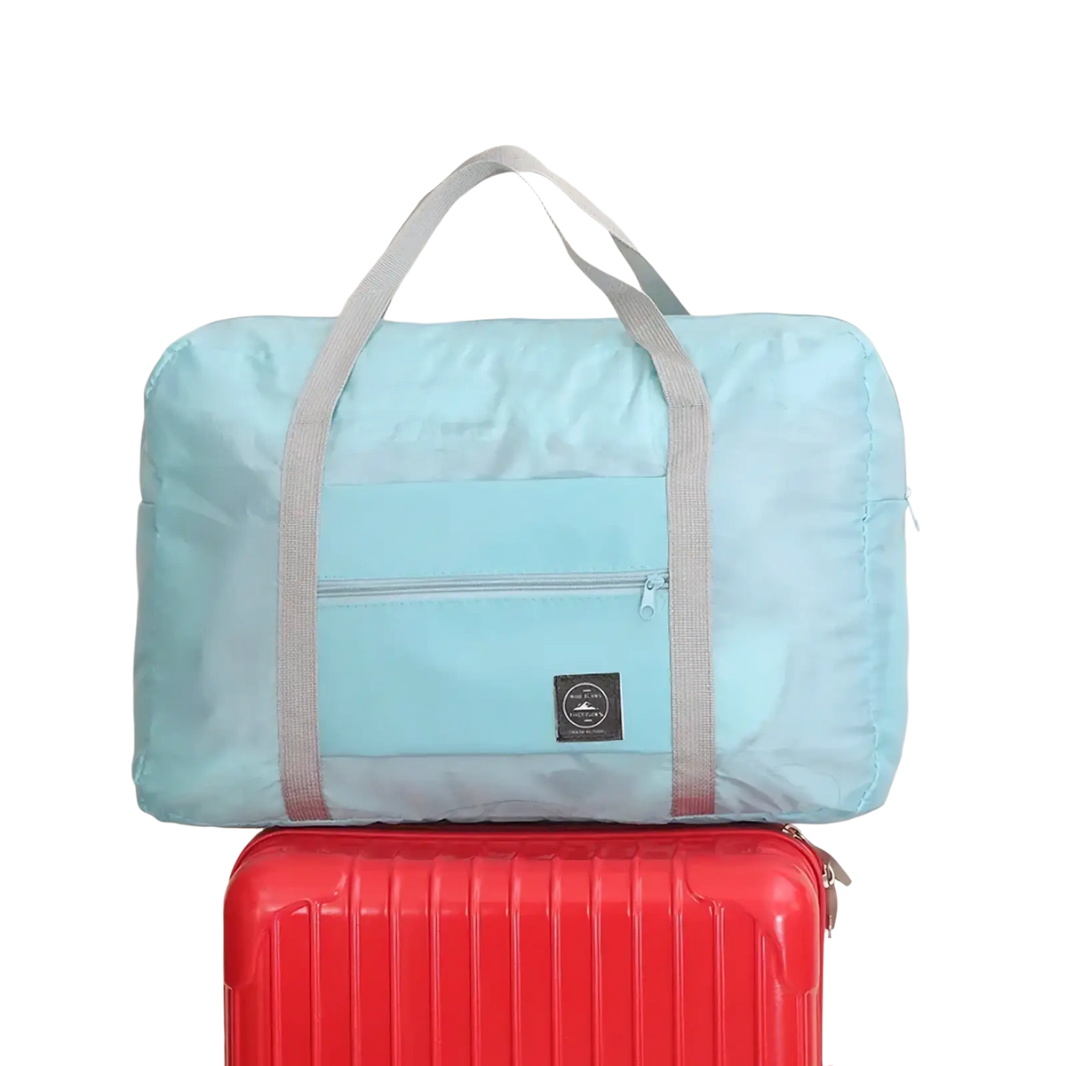 Light blue foldable canvas travel bag with gray straps and front zippered pocket for convenient packing and carrying