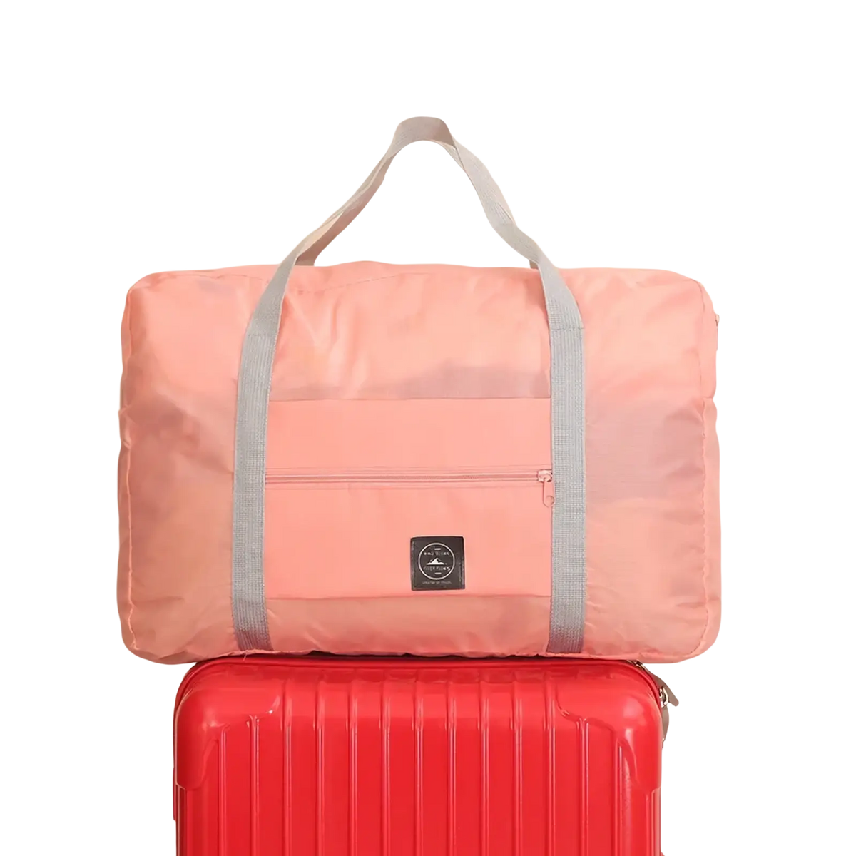 Pink foldable canvas travel bag with gray straps and small black logo patch from the foldable canvas travel bag set