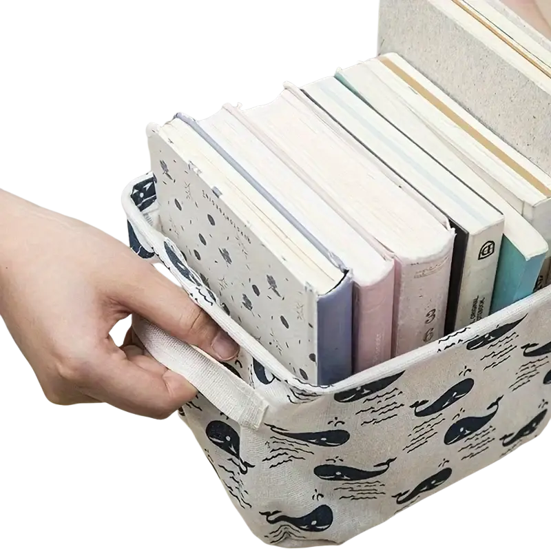 Cream-colored foldable fabric storage basket with black whale and wave pattern and sturdy handles for easy carrying storage box