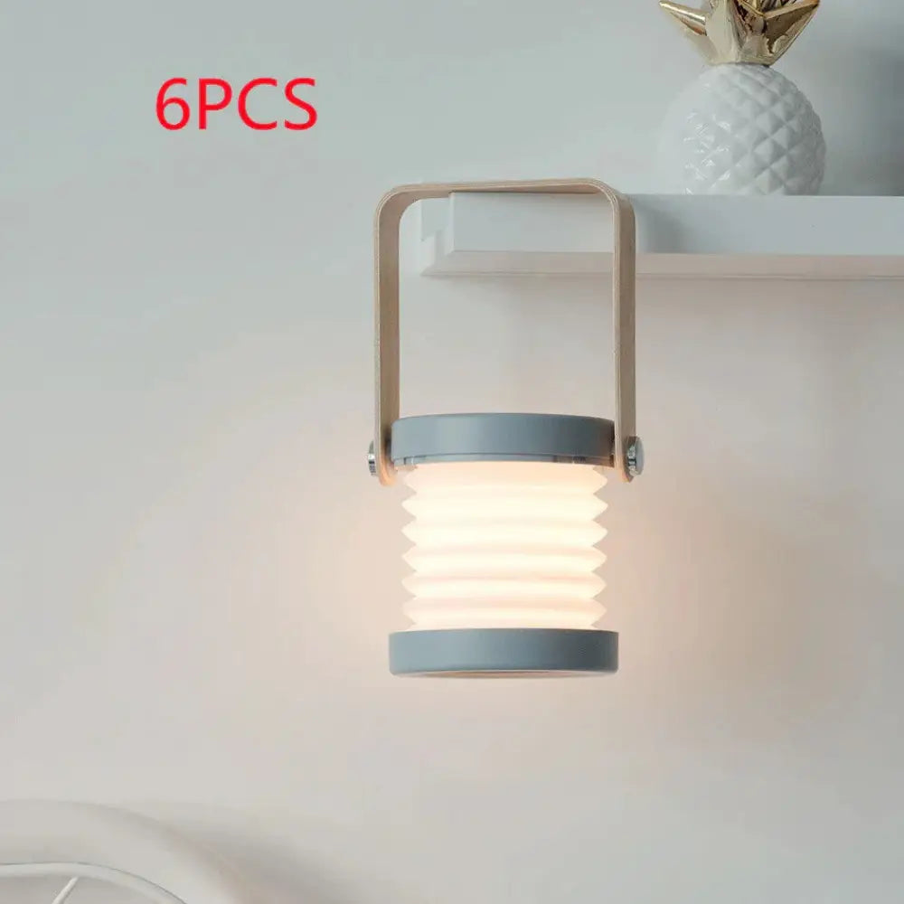 Gray foldable touch dimmable led lantern with metallic handle emitting warm diffused light for portable use