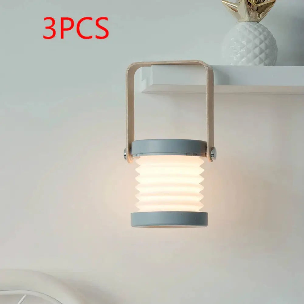 Gray foldable touch dimmable led lantern with metallic handle emitting warm light for portable table lamp use