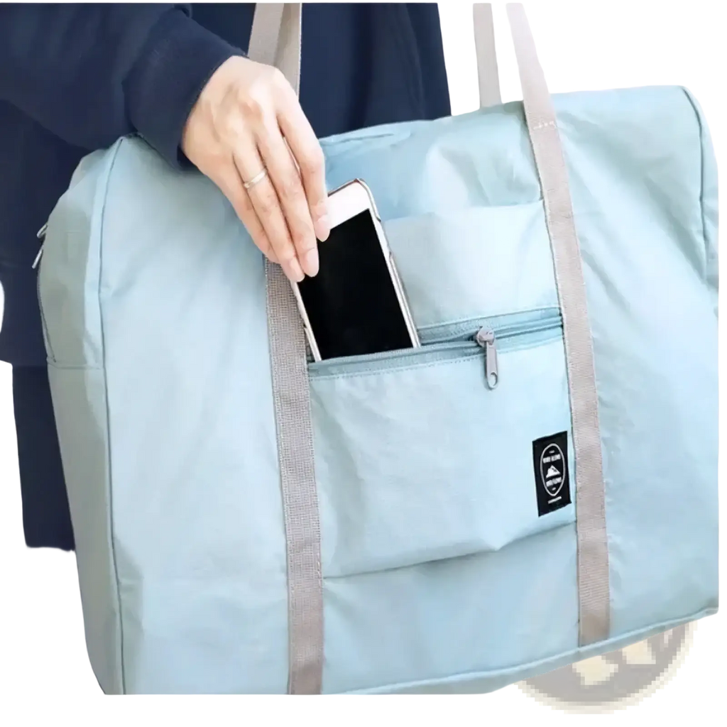 Light blue lightweight foldable travel duffel bag with gray straps and front zippered pocket for easy carrying