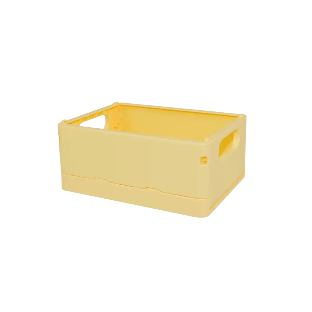 A pale yellow foldable plastic storage box with integrated handles designed as a compact desktop organizer