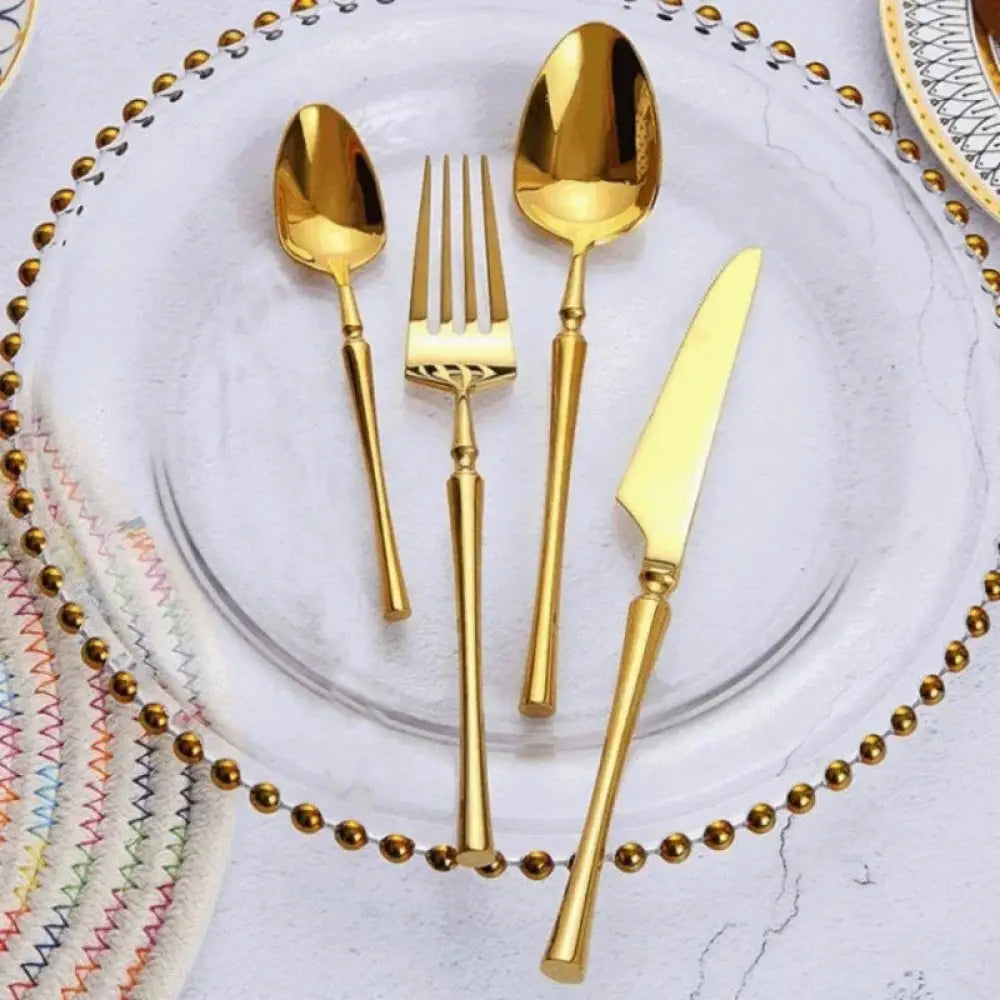 Modern 4-piece stainless steel steak cutlery set with golden ornate handles and polished blades
