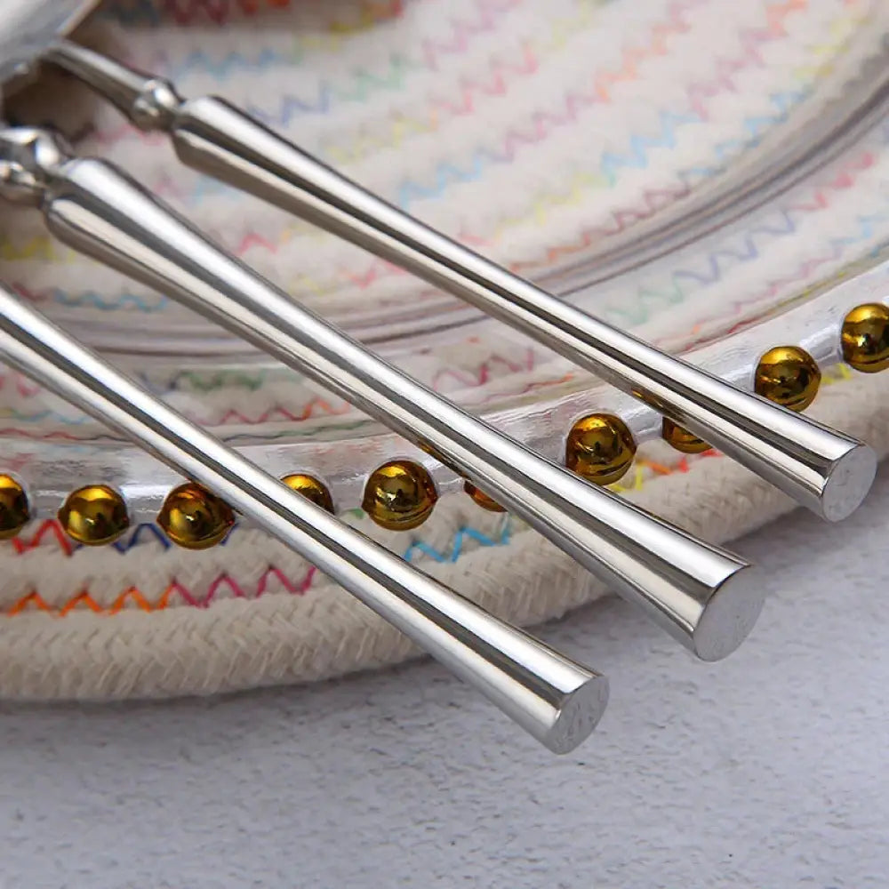 Modern 4-piece stainless steel steak cutlery set featuring shiny silver chopsticks with golden spherical beads