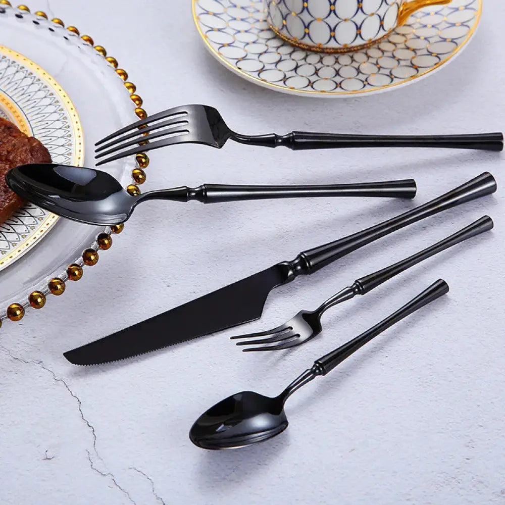 Modern 4-piece stainless steel steak cutlery set with black matte finish and elegant slightly curved handles