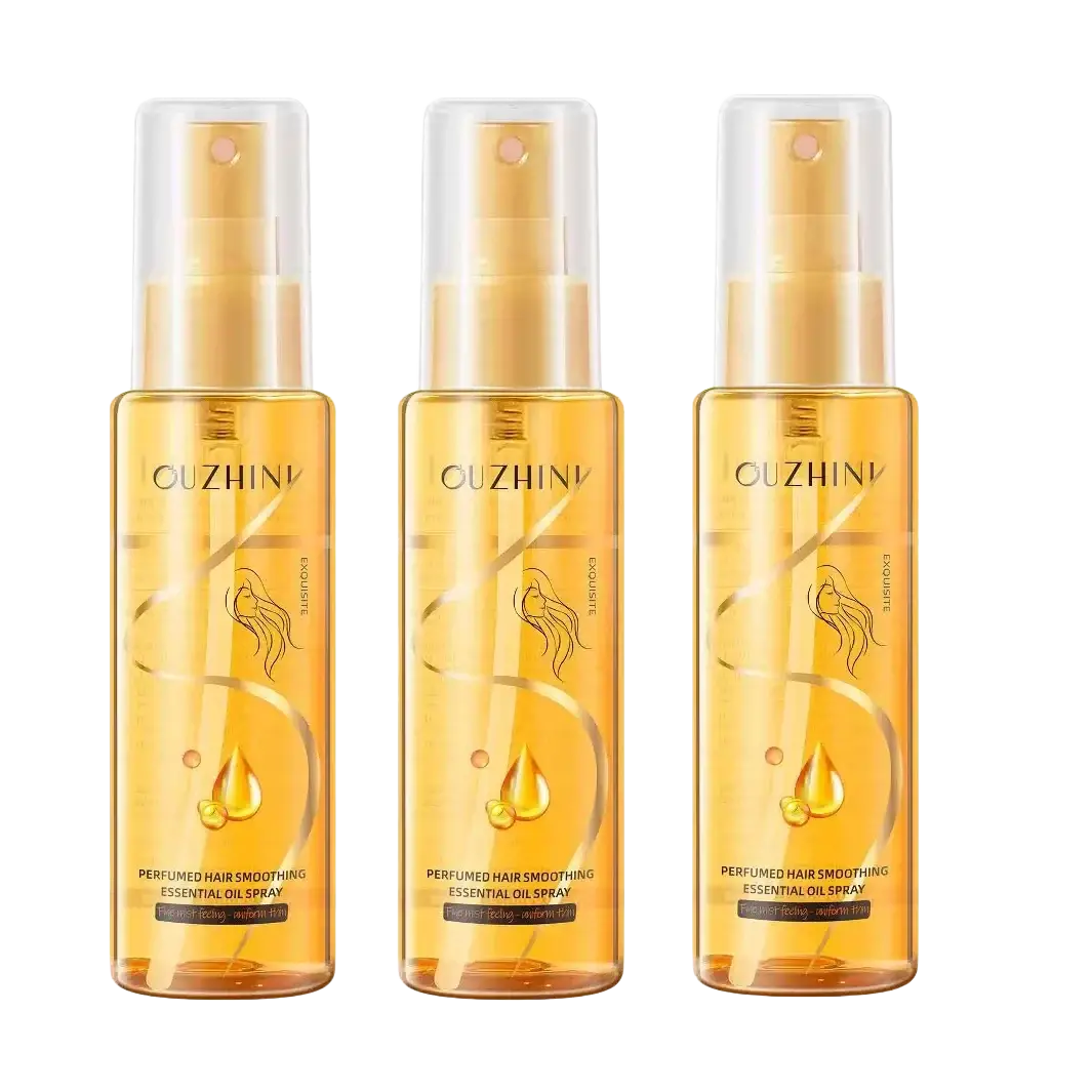 Three amber-colored glass bottles of Ouzhini fragrance hair care essential oil spray with gold-toned caps and clear nozzles