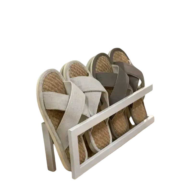 White wooden freestanding metal shoe rack holding woven espadrille sandals with light and dark gray fabric straps