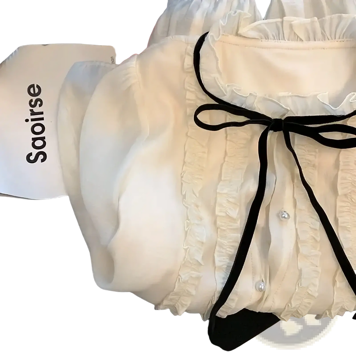 Cream-colored French chic lace bow tie blouse with delicate ruffles black ribbon tie and pearl buttons at neckline