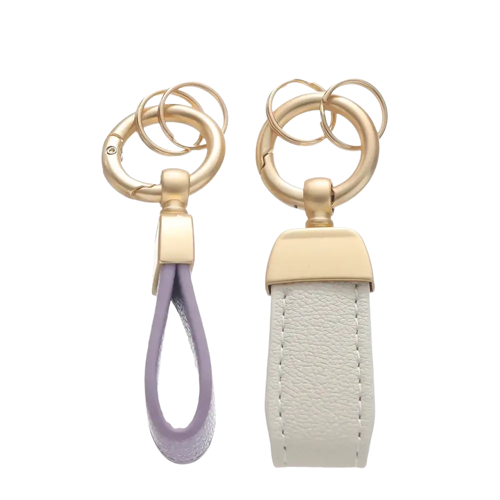 Two french sheepskin leather car key chain pendants with lavender and off-white straps and gold-toned hardware