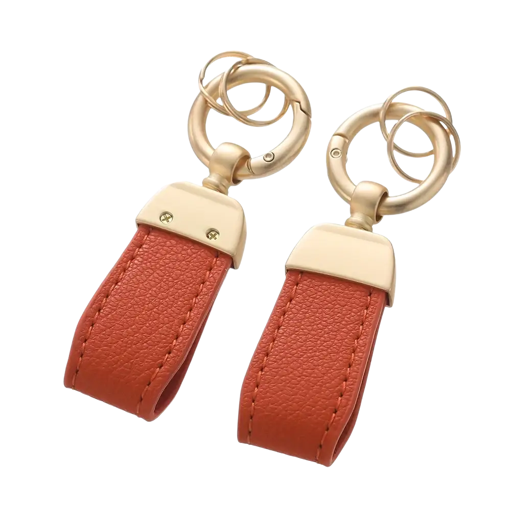A pair of orange french sheepskin leather car key chain pendants with gold-tone metal hardware and double-ring design