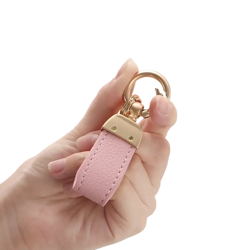 A delicate pink french sheepskin leather car key chain pendant with gold-tone metal clasp and ring