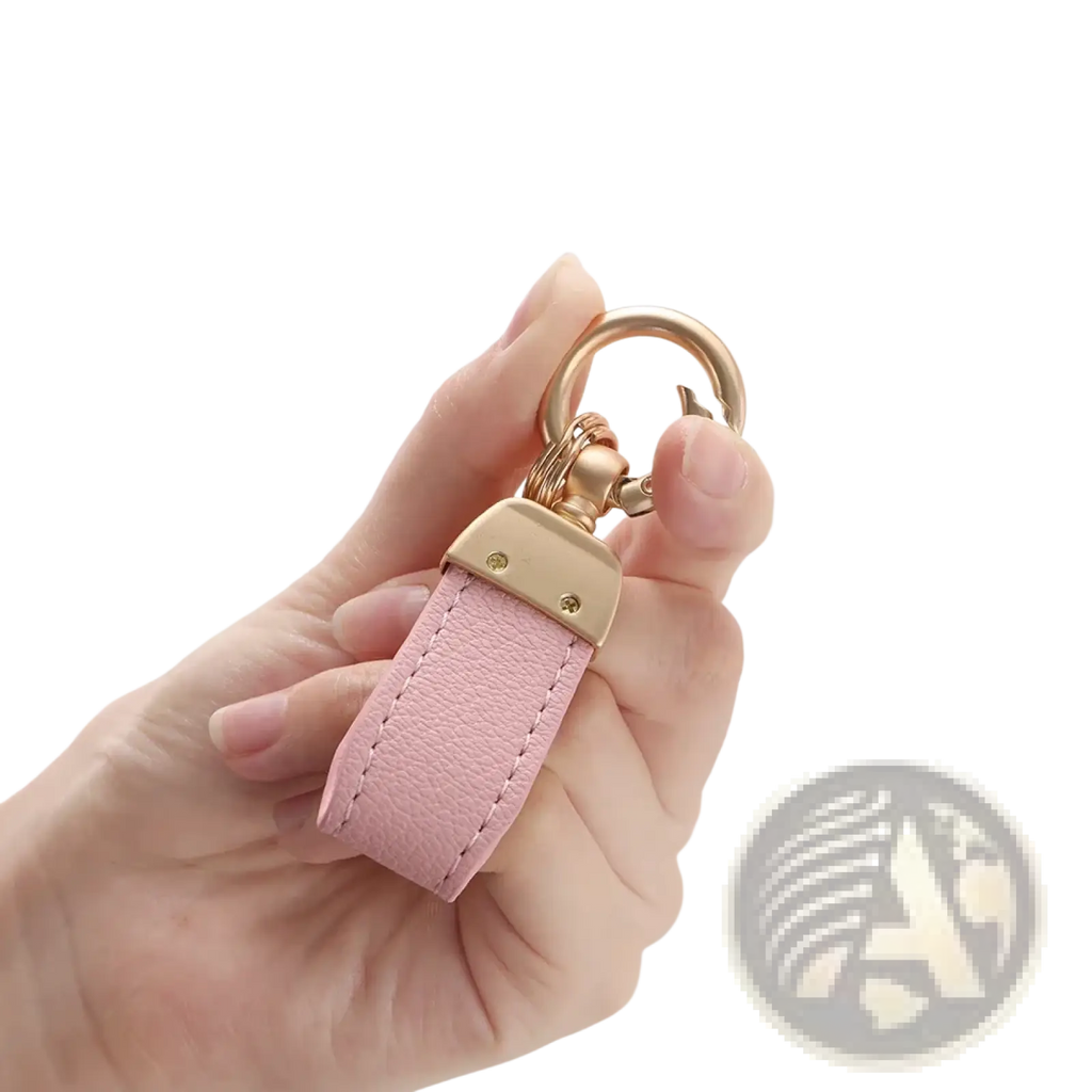 A delicate pink french sheepskin leather car key chain pendant with gold-tone metal clasp and ring