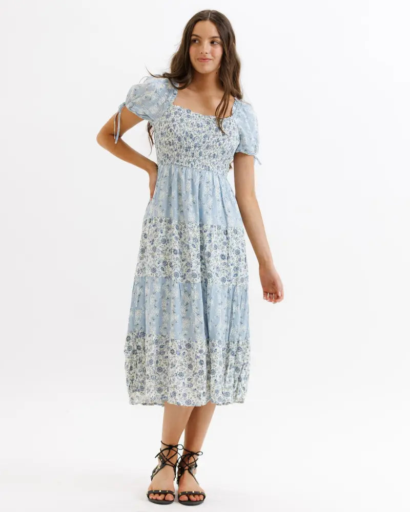 A light blue floral print tiered midi dress with puffed short sleeves and square neckline for spring wear