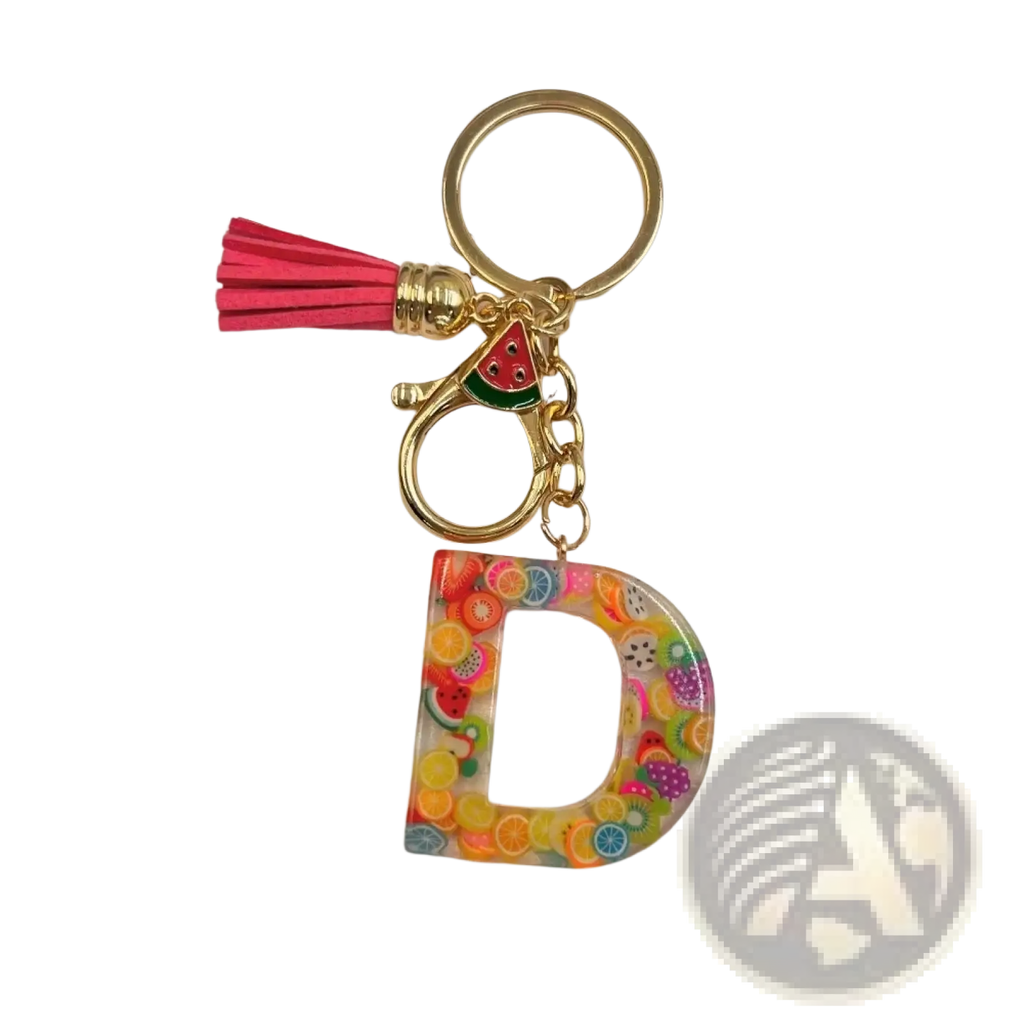 A vibrant transparent resin fruit letter d keychain with colorful fruit slices gold ring and pink tassel accessory