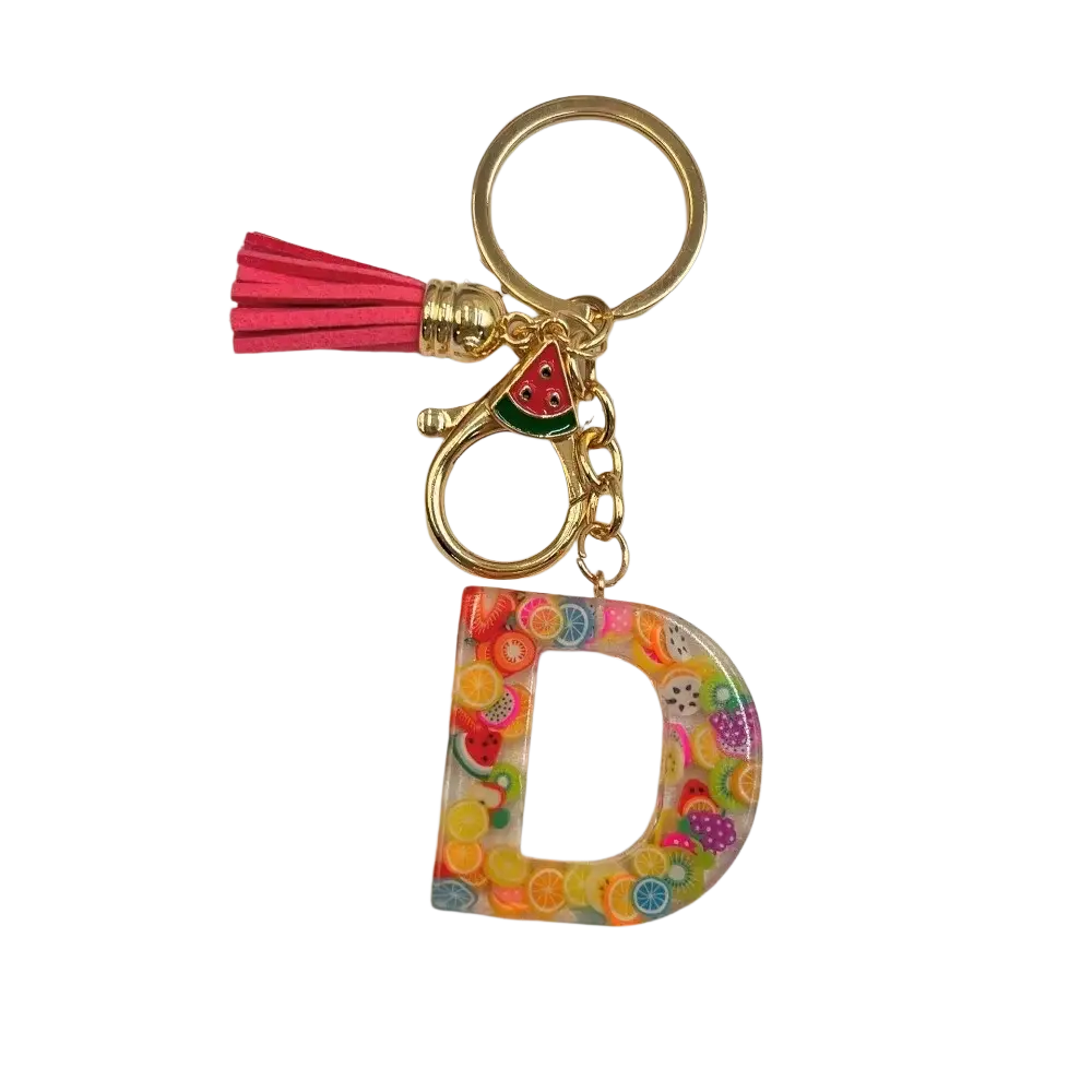 A vibrant transparent resin fruit letter d keychain with colorful fruit slices gold ring and pink tassel accessory