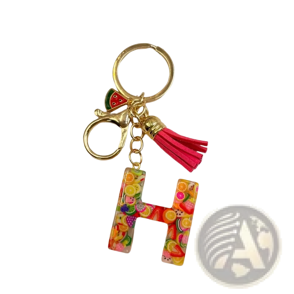 A vibrant translucent resin letter h keychain with colorful fruit slices gold ring clasp and pink tassel