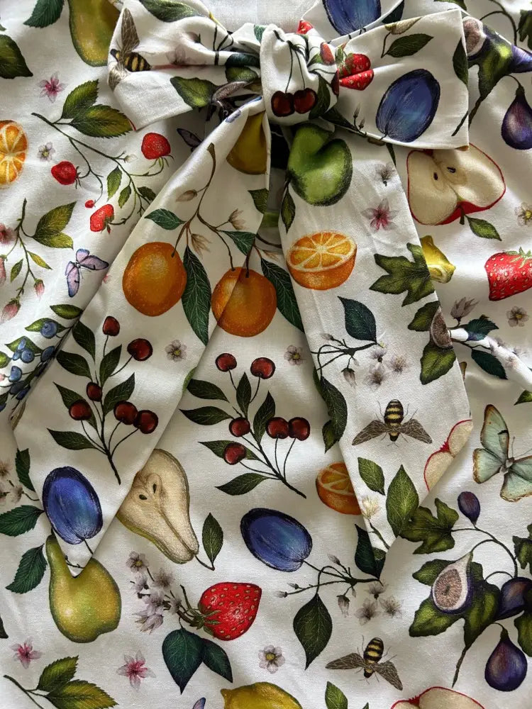 White cotton bow top with vibrant vintage 1950s fruit and butterfly print on fabric featuring oranges pears and bees