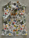 A white sleeveless vintage 1950s cotton blouse with vibrant fruit and butterfly print and a tied bow collar
