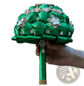 A lush emerald green satin bridal bouquet with sparkling rhinestone flowers and pearl accents for weddings