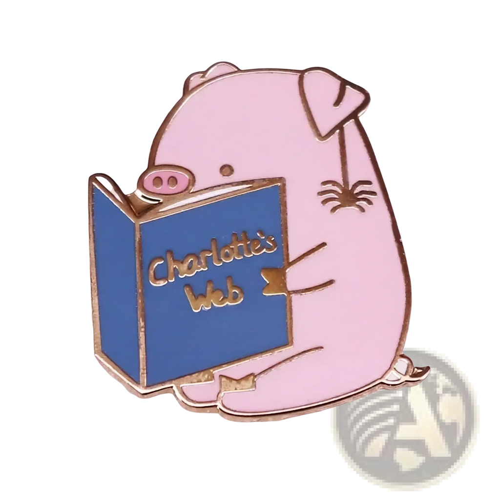 Pink enamel pin featuring a cartoon pig reading a blue charlottes web book with gold-trimmed edges and lettering